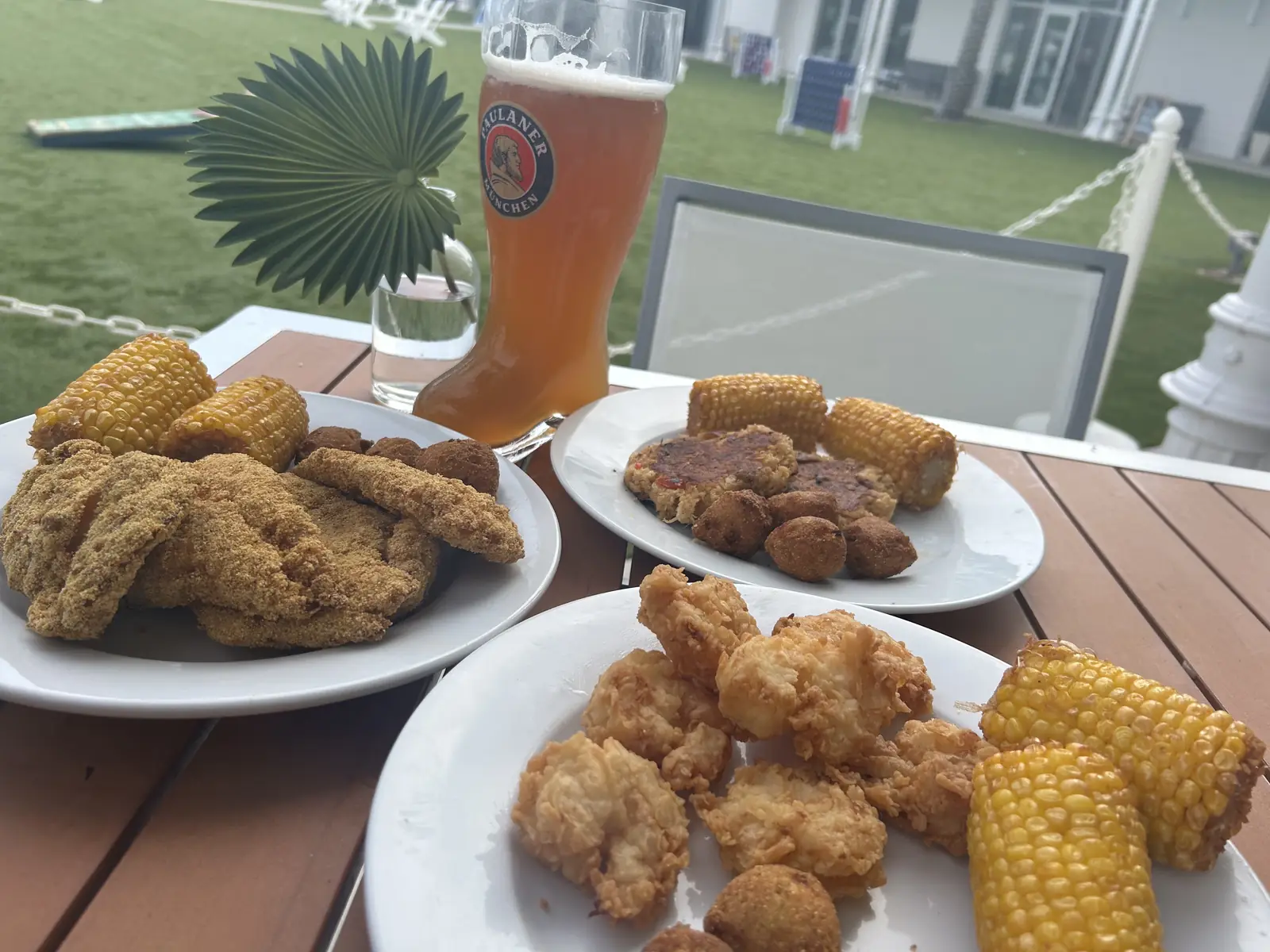 Fried shrimp, chicken and corn on the cob beside a tall beer on the deck at Tee Off at The Wharf